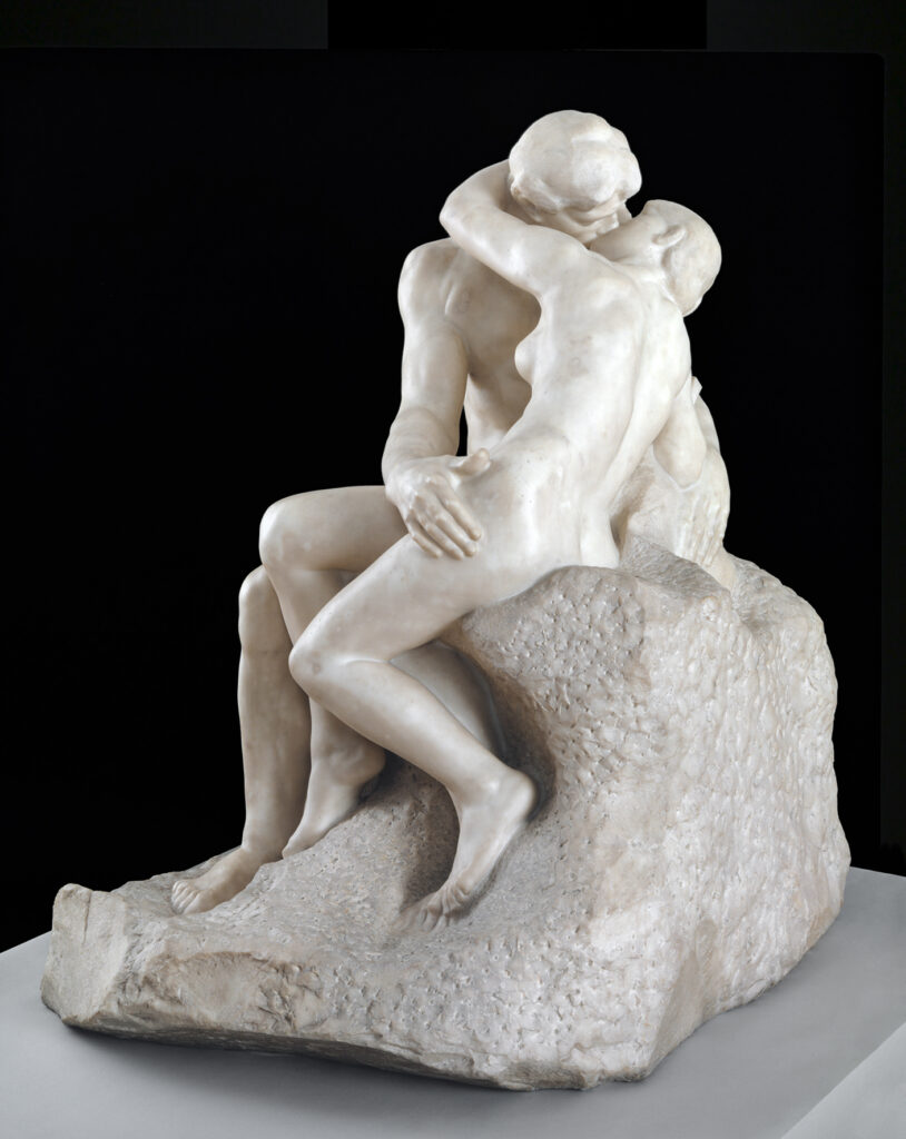 Die Marmorfigur zeigt zwei nackte Personen in einem intimen Moment. Während sie sich leidenschaftlich küssen, umschlingen sie sich mit ihren Armen und Händen gegenseitig. Hier nimmt die Frau eine aktive Rolle ein.